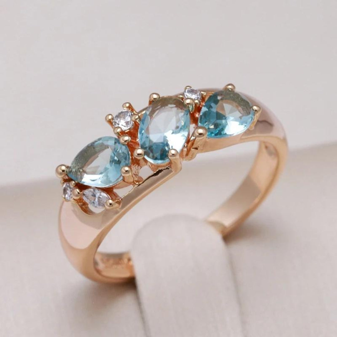 Élégante bague vintage bleue avec des pierres en zircon dans un cadre doré.